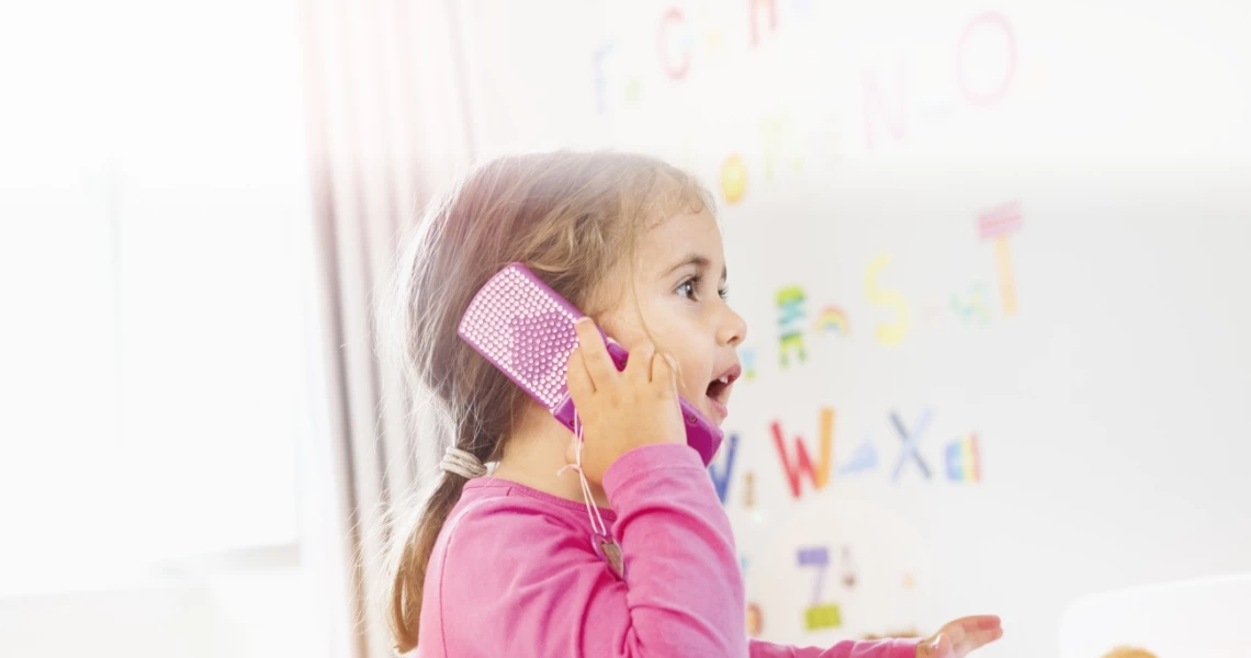 dziecko z telefonem różowym przy uchu